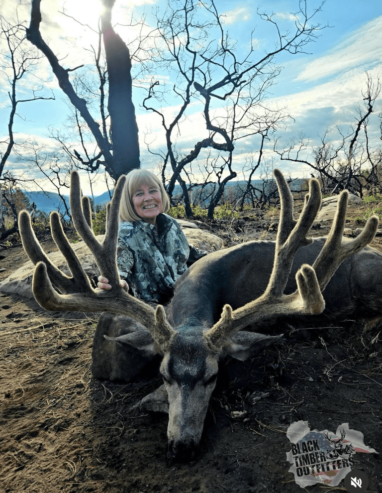Hunter with a velvet-antlered mule deer in the Black Timber hunt archive