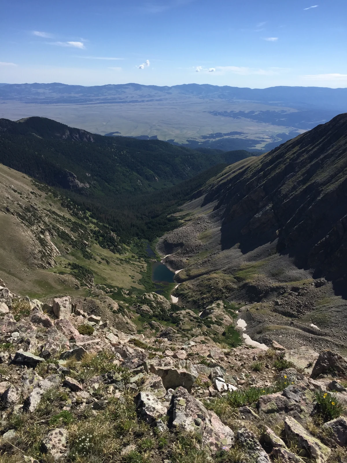 Colorado alpine valley with small mountain lakes, rocky slopes and distant plains